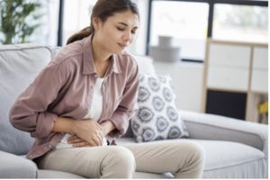 Woman clutching abdomen in pain.